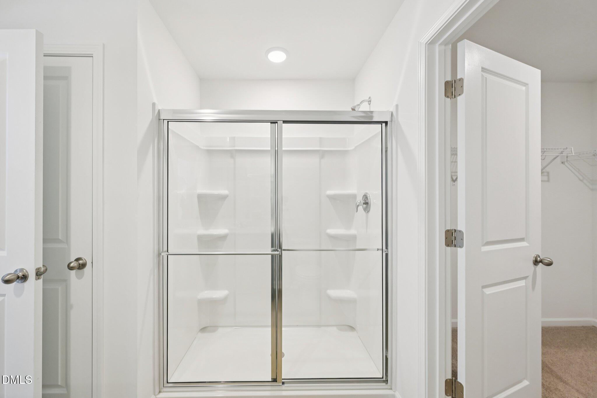 11793 Salers Loop Middlesex, NC 27557 - Photo 30 of 53 a bathroom with a glass shower door