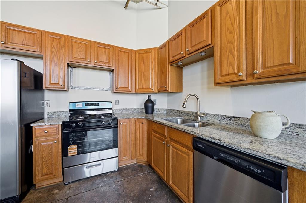 505 Whitehall Street Southwest, Unit 204 Atlanta, GA 30303 - Photo 9 of 33 a kitchen with granite countertop a sink stove and cabinets