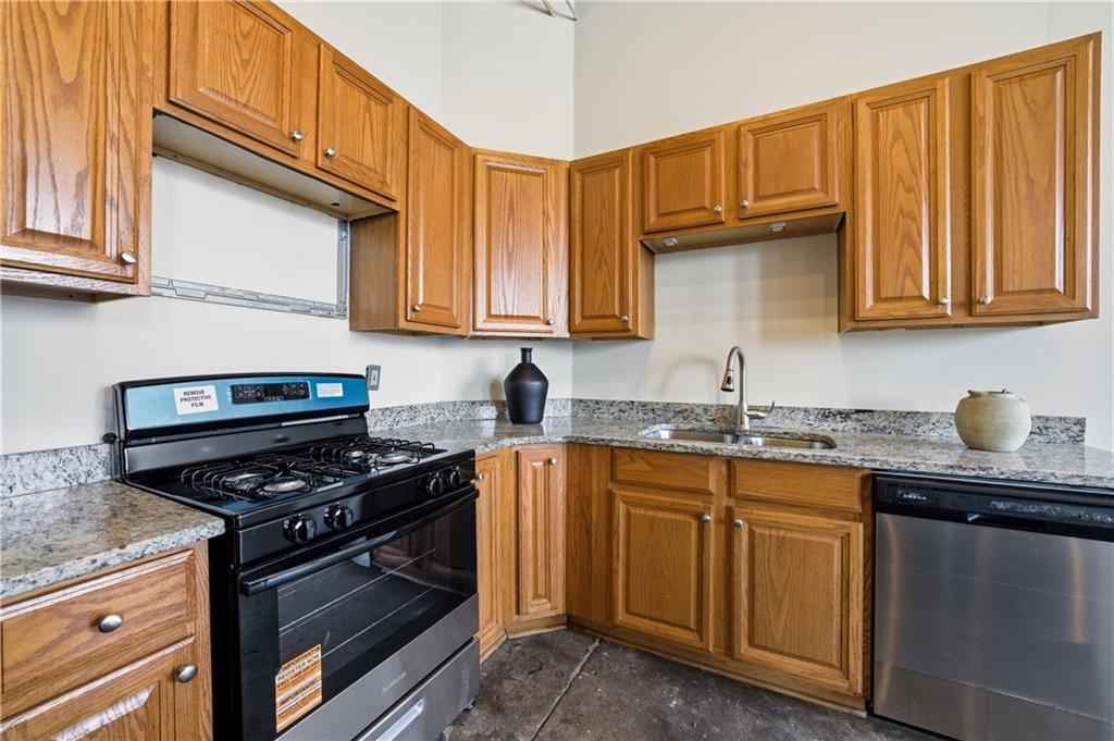 505 Whitehall Street Southwest, Unit 204 Atlanta, GA 30303 - Photo 10 of 33 a kitchen with granite countertop a stove sink and cabinets