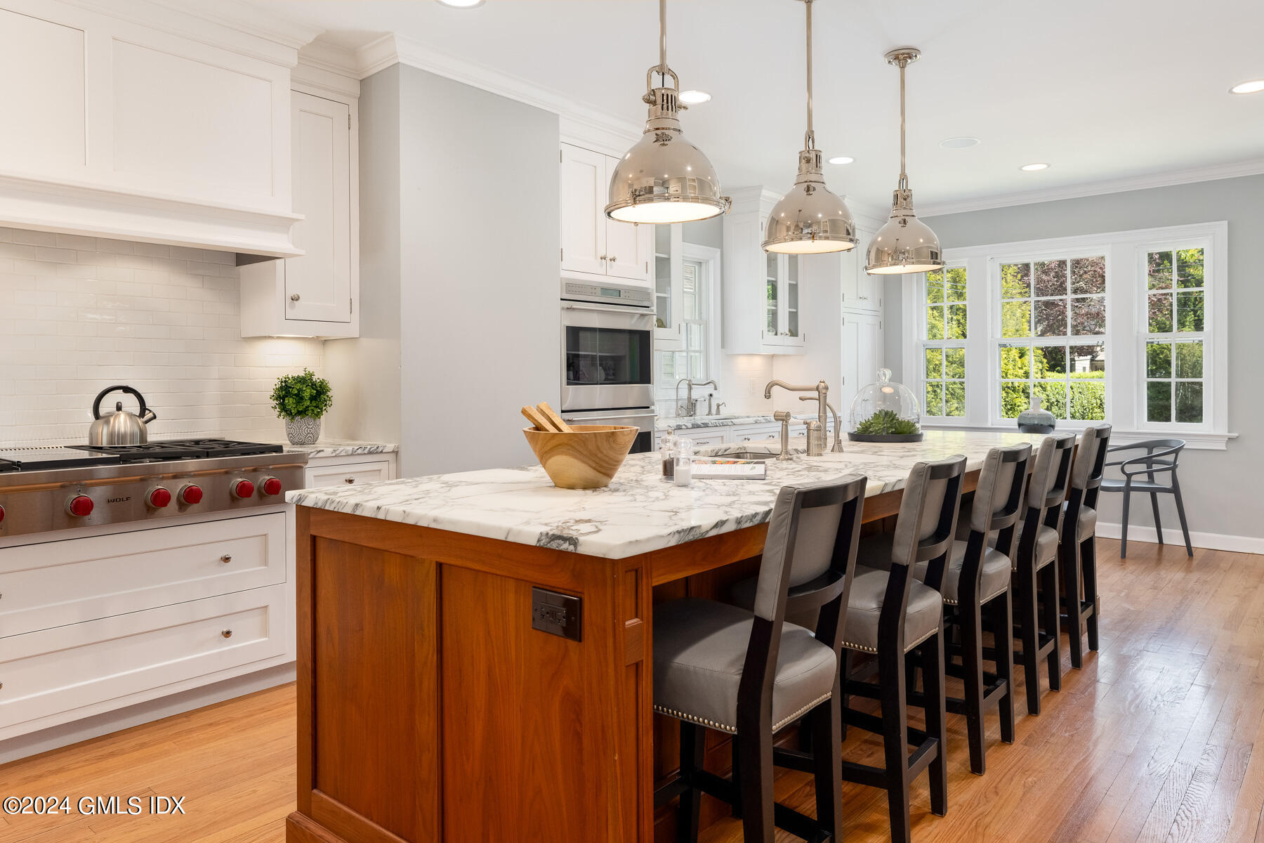 89 Shore Road Old Greenwich, CT 06870 - Photo 11 of 36 a open kitchen with granite countertop a stove a sink a dining table and chairs with wooden floor