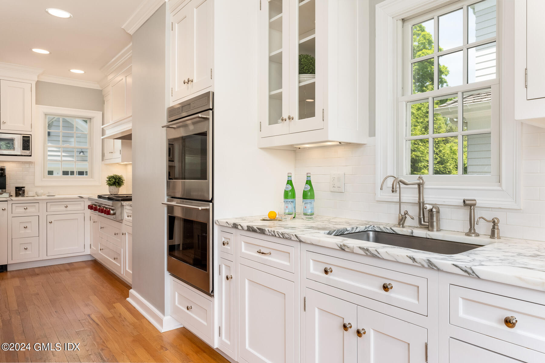 89 Shore Road Old Greenwich, CT 06870 - Photo 10 of 36 a kitchen with granite countertop white cabinets and white appliances