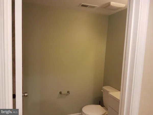 a white toilet sitting next to a white wall