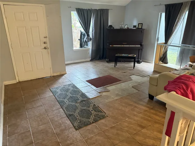 a living room with furniture and a piano