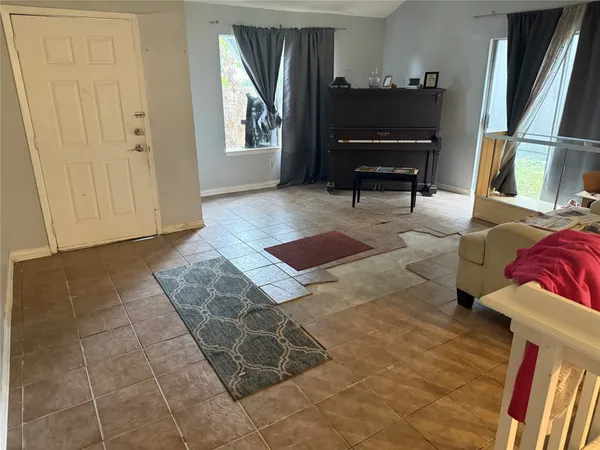 a living room with furniture and a piano
