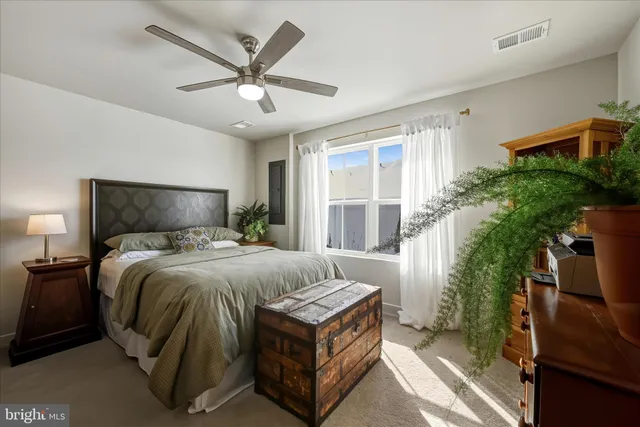 a bed sitting in a bedroom next to a window and a flat screen tv