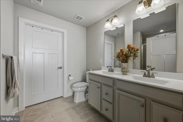 a bathroom with a granite countertop sink toilet and mirror