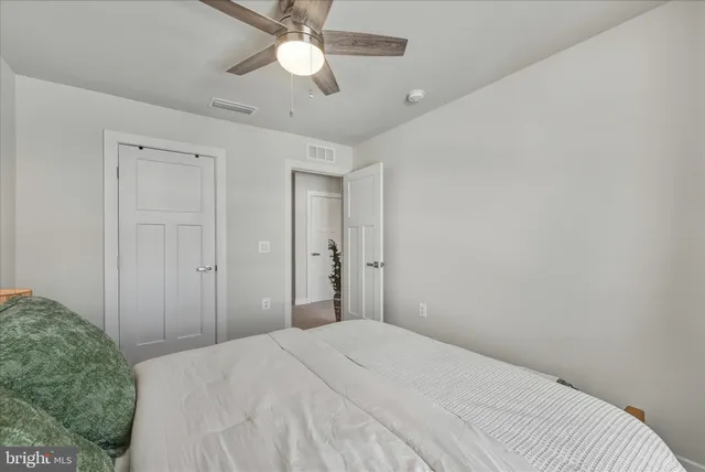 a bedroom with a bed and a chandelier fan