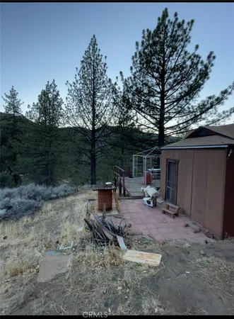 a view of a backyard with table and chairs under an umbrella
