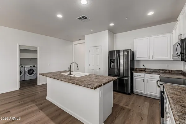 a kitchen with stainless steel appliances granite countertop a sink stove and refrigerator