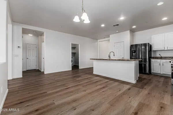 a view of a kitchen with stainless steel appliances a refrigerator and a stove top oven
