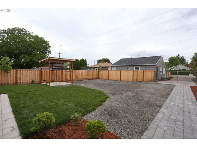 a view of a backyard with grass and a garden
