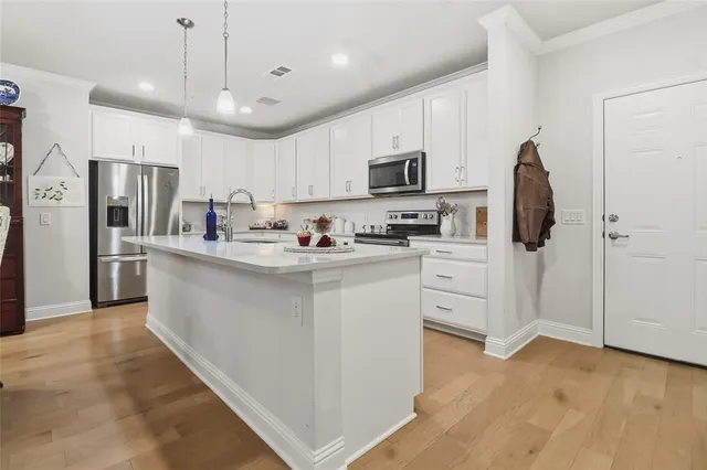 a large white kitchen with cabinets and stainless steel appliances