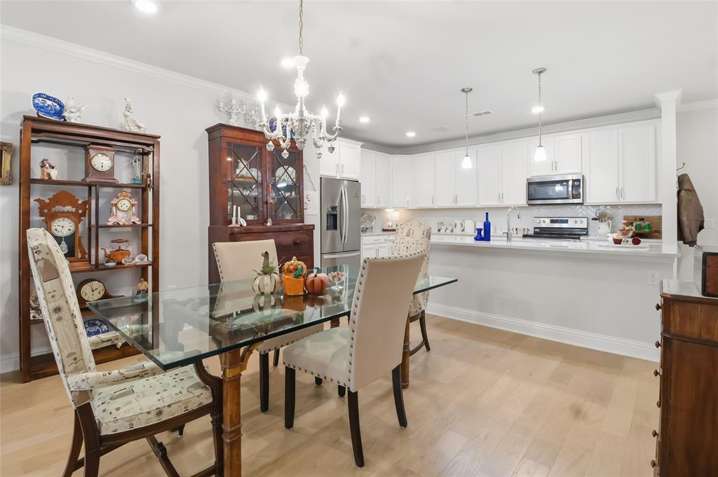 651 Watters Road, Unit 8202 Allen, TX 75013 - Photo 6 of 32 a kitchen with kitchen island a stove a table and chairs in it