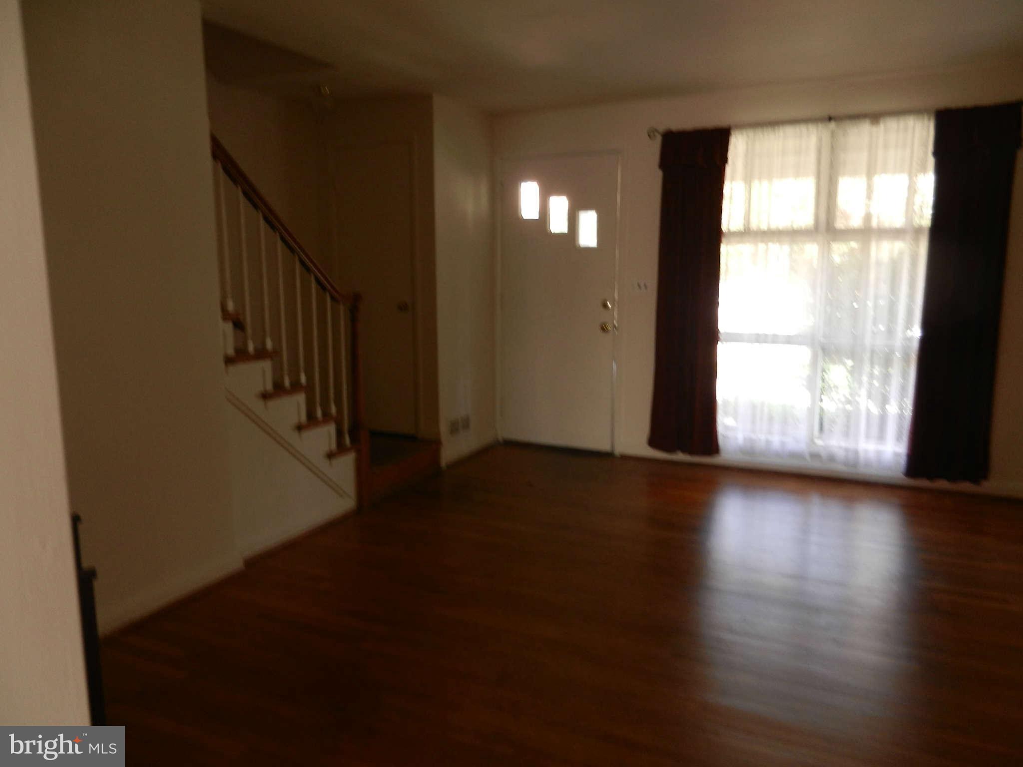 6124 Marlora Road Baltimore, MD 21239 - Photo 2 of 12 a view of an empty room with wooden floor and windows