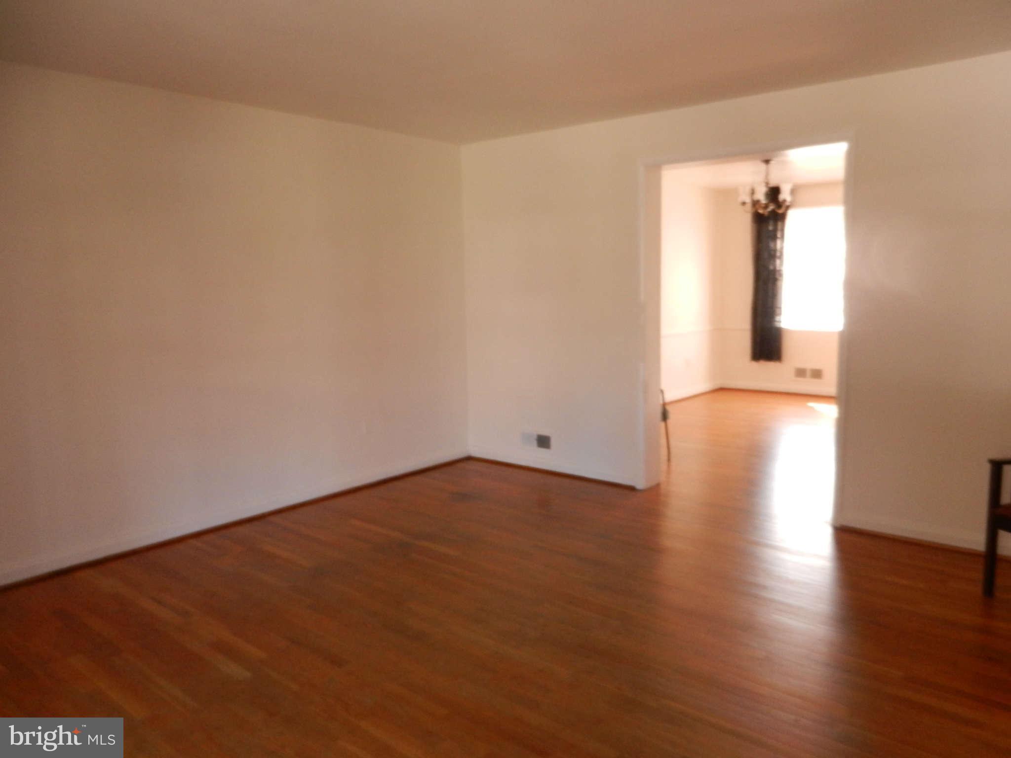 6124 Marlora Road Baltimore, MD 21239 - Photo 3 of 12 an empty room with wooden floor and windows