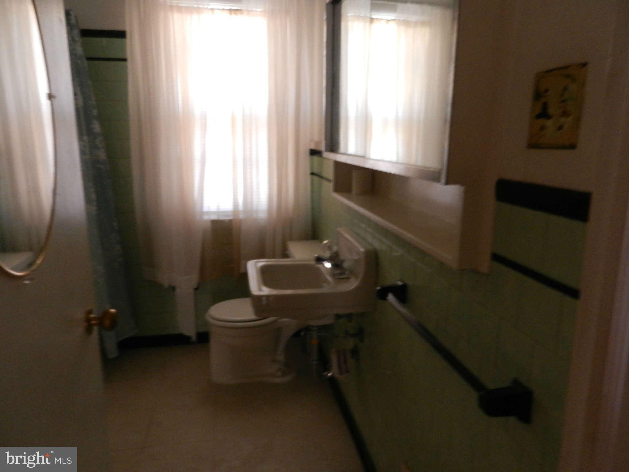 6124 Marlora Road Baltimore, MD 21239 - Photo 9 of 12 a bathroom with a sink a toilet and a window