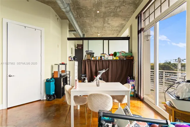 a view of a hallway with a dining table and chairs