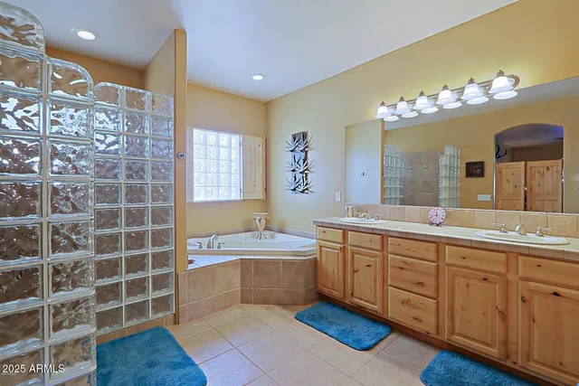 a spacious bathroom with a double vanity sink a mirror and a bathtub