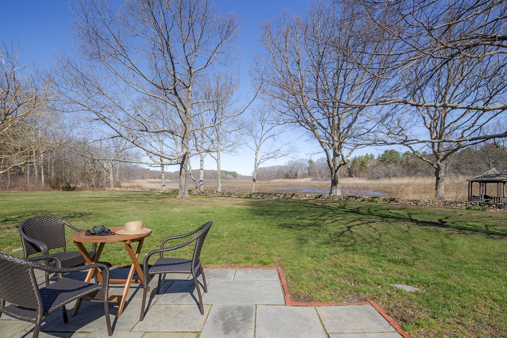 134 Argilla Road Ipswich, MA 01938 - Photo 10 of 10 a view of a backyard with table and chairs and a fire pit