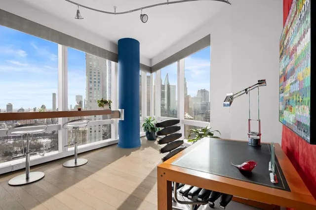 a living room with patio furniture and a floor to ceiling window