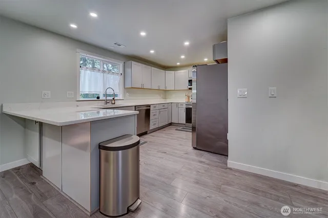 a kitchen with a sink cabinets and wooden floor