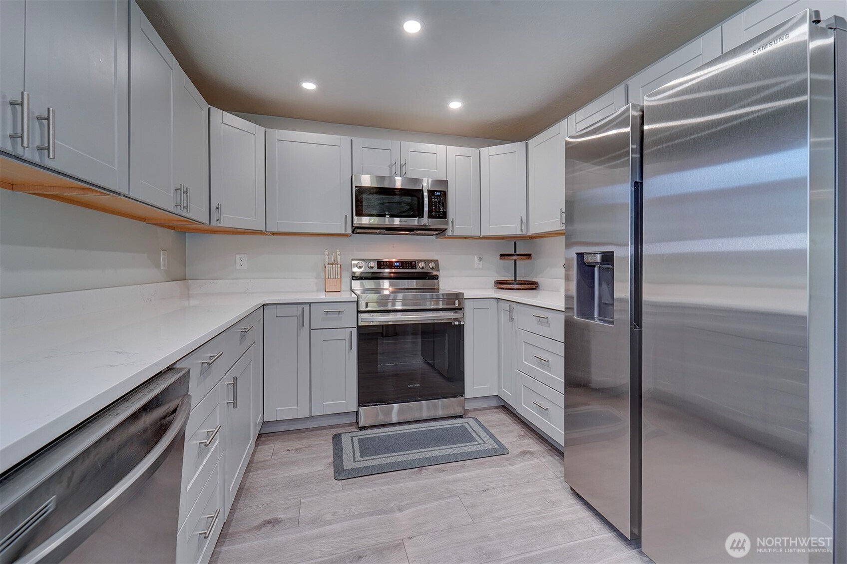 4931 Knute Anderson Road Northwest Silverdale, WA 98383 - Photo 13 of 37 a kitchen with white cabinets and stainless steel appliances