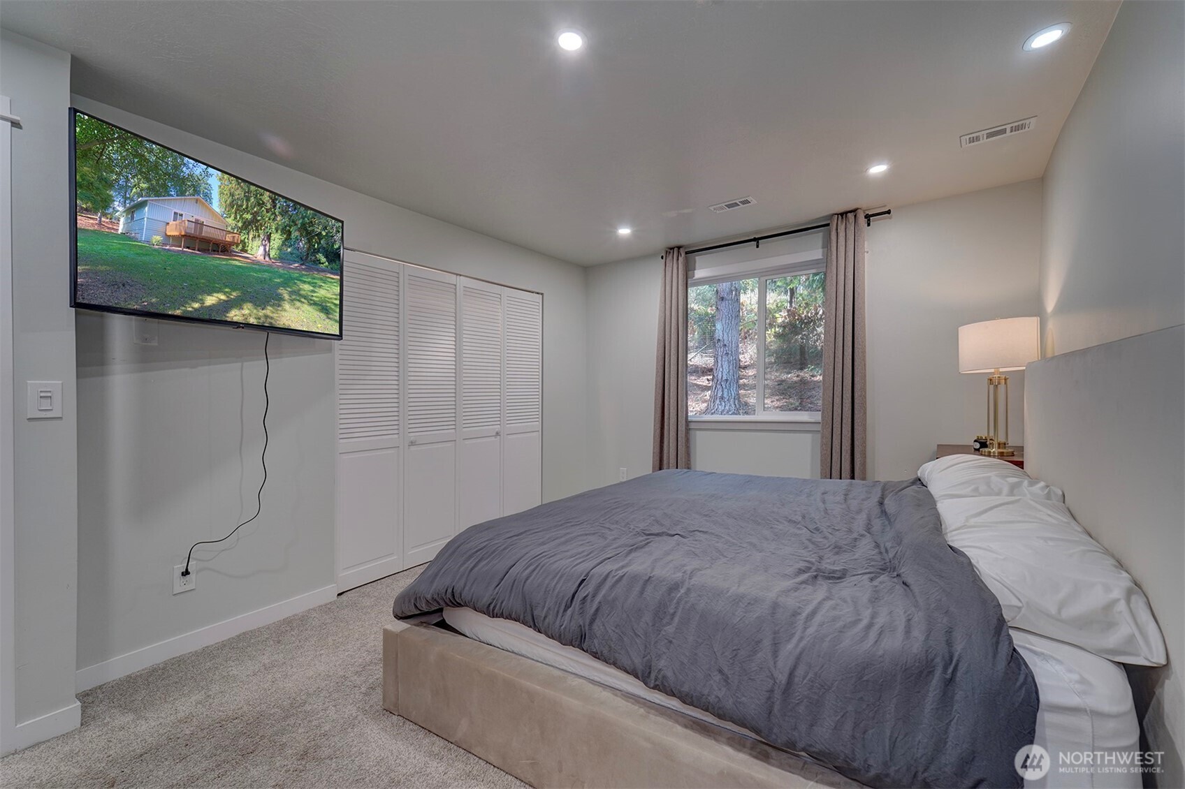 4931 Knute Anderson Road Northwest Silverdale, WA 98383 - Photo 20 of 37 a spacious bedroom with a bed and a painting on the wall