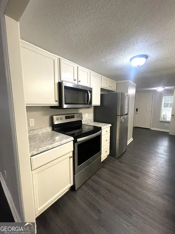 a kitchen with stainless steel appliances a refrigerator microwave and stove