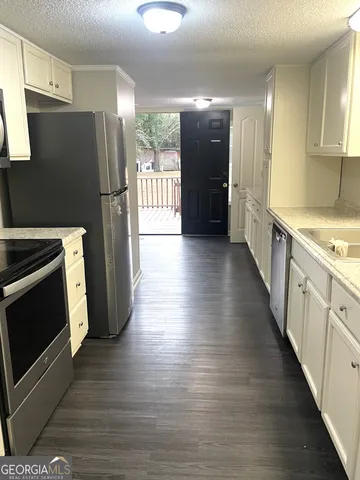 a kitchen with stainless steel appliances a refrigerator and a stove top oven