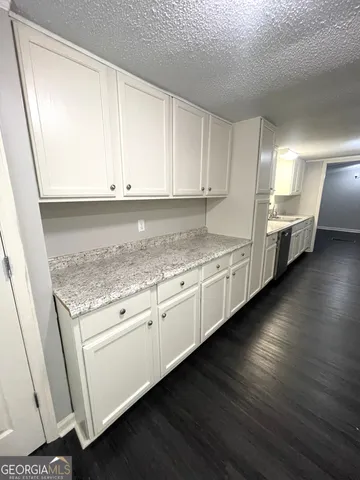 a kitchen with stainless steel appliances granite countertop a stove a sink and white cabinets