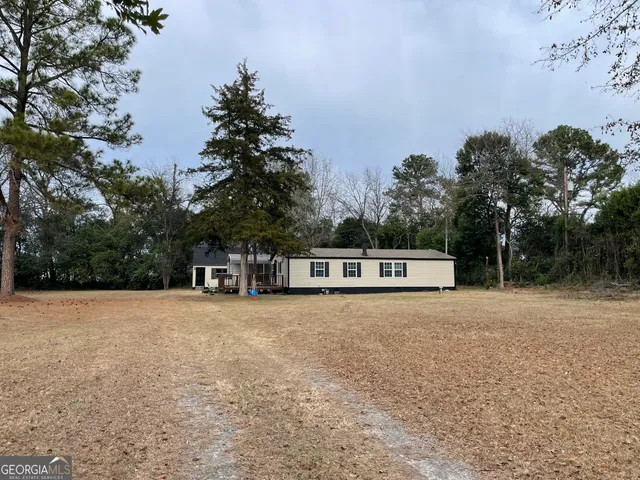 a view of large trees with wooden fence