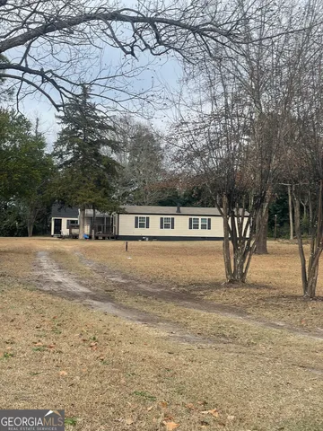 a view of residential houses with yard and trees