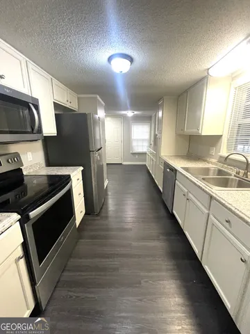 a kitchen with stainless steel appliances kitchen island granite countertop a stove a sink and a microwave