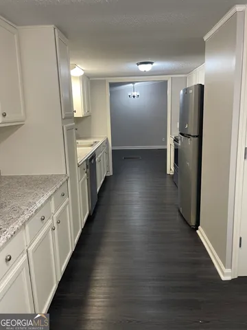 a view of a kitchen with a sink and refrigerator