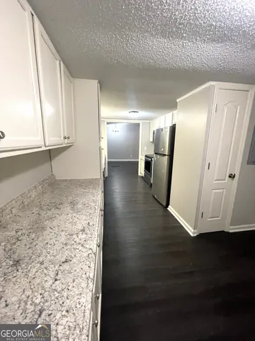 a view of a refrigerator in kitchen and wooden floor