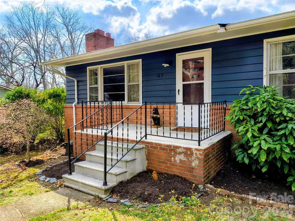 a view of a small house with wooden fence