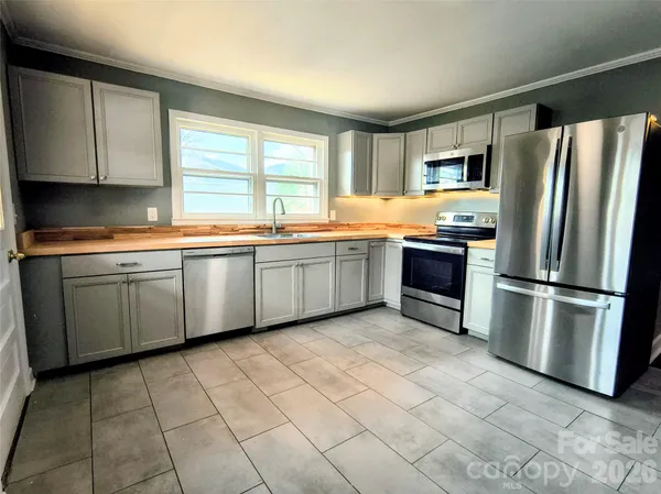 a kitchen with stainless steel appliances granite countertop a sink and a refrigerator