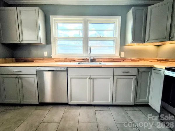 a kitchen with granite countertop white cabinets and a sink