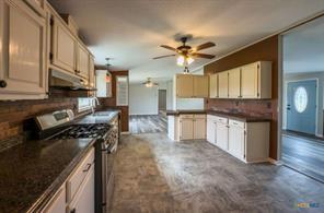 3627 North Katy Road Ross, TX 76640 - Photo 14 of 31 a kitchen with a stove a sink and a refrigerator