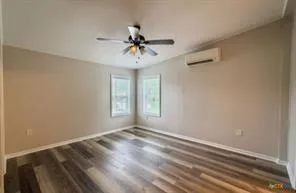 a view of a livingroom with a chandelier fan and a window