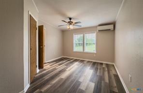 3627 North Katy Road Ross, TX 76640 - Photo 18 of 31 Unfurnished bedroom with dark wood-type flooring, a ceiling fan, and crown molding