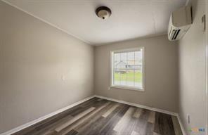 3627 North Katy Road Ross, TX 76640 - Photo 19 of 31 Unfurnished room featuring a mini split for heating / cooling and dark wood-style flooring
