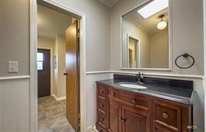 3627 North Katy Road Ross, TX 76640 - Photo 22 of 31 Bathroom featuring vanity, a skylight, and a wainscoted wall