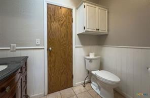 3627 North Katy Road Ross, TX 76640 - Photo 24 of 31 a bathroom with a granite countertop toilet and a sink