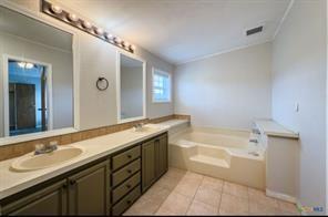 3627 North Katy Road Ross, TX 76640 - Photo 26 of 31 Bathroom with a bath, double vanity, light tile patterned floors, and crown molding