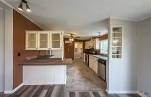 a kitchen with a sink appliances cabinets and a window