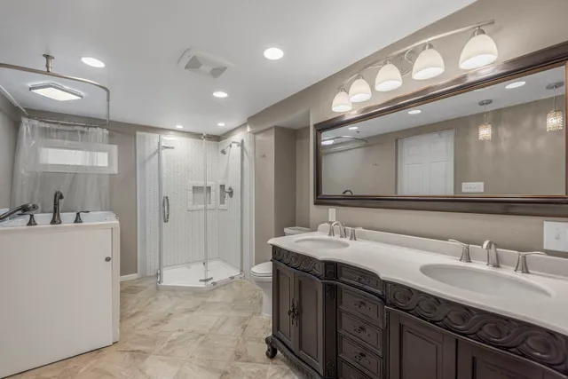 a bathroom with a double vanity sink mirror and shower