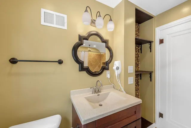 a bathroom with a sink mirror and toilet