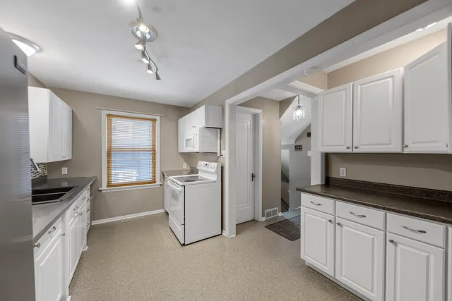 a kitchen with a refrigerator and a stove top oven