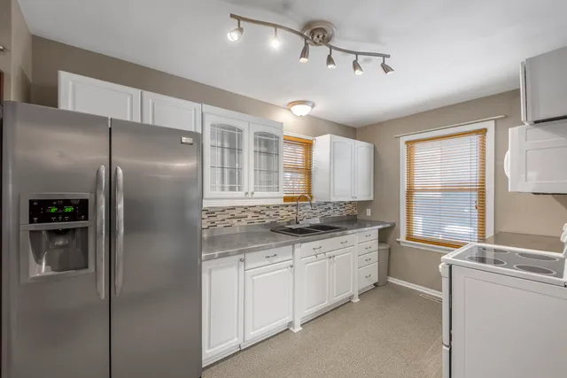a kitchen with stainless steel appliances granite countertop a refrigerator and a sink